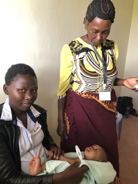 Community health worker examining newborn